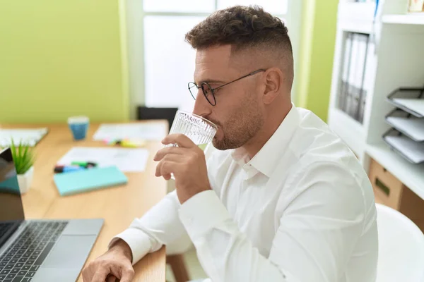 オフィスでラップトップ飲料水を使用して若いヒスパニック系の男のビジネスワーカー — ストック写真