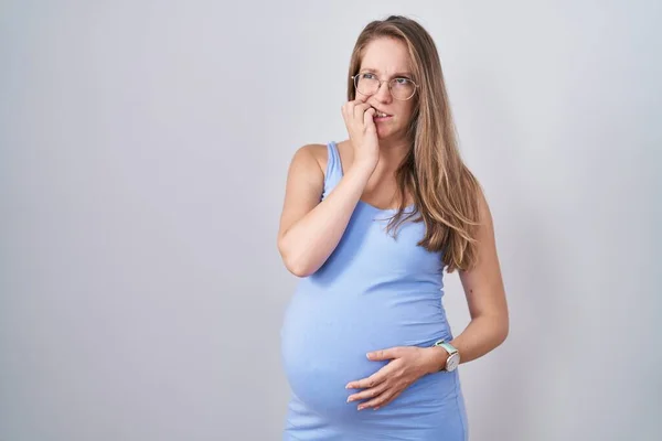 Mladá Těhotná Žena Stojí Nad Bílým Pozadím Vypadá Vystresovaně Nervózně — Stock fotografie