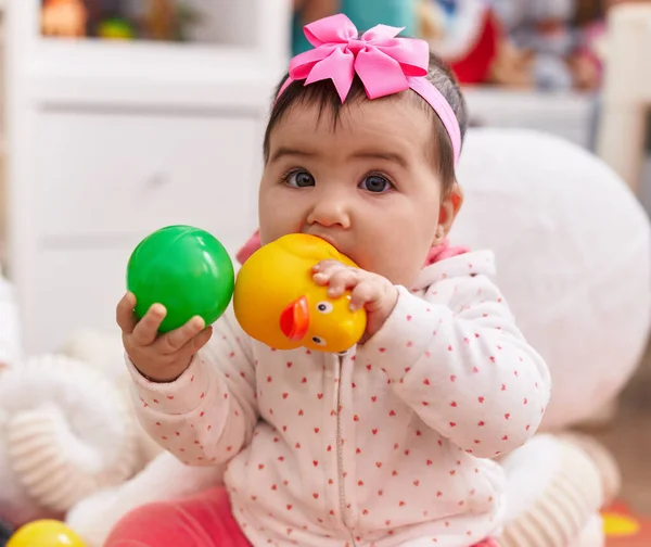 Förtjusande Latinamerikansk Bebis Som Sitter Golvet Och Suger Ankleksak Hemma — Stockfoto
