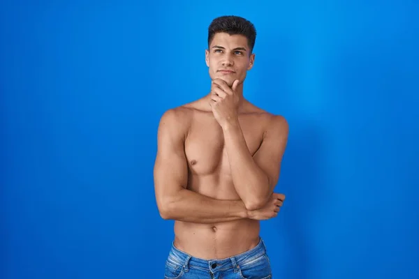 Homem Hispânico Jovem Sem Camisa Sobre Fundo Azul Olhando Confiante — Fotografia de Stock