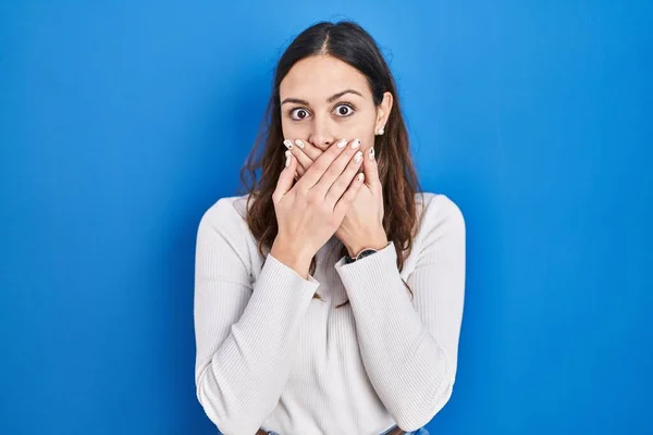 Young Hispanic Woman Standing Blue Background Shocked Covering Mouth Hands — Stockfoto
