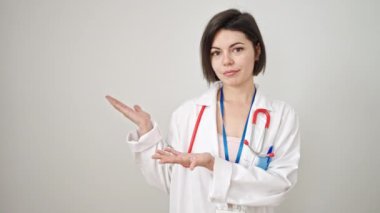 Beyaz arka planda kendinden emin bir şekilde gülümseyen beyaz kadın doktor.