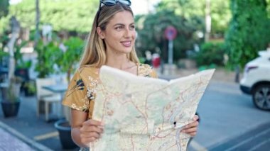Genç sarışın kadın turist gülümsüyor. Kendine güvenen şehir haritası.