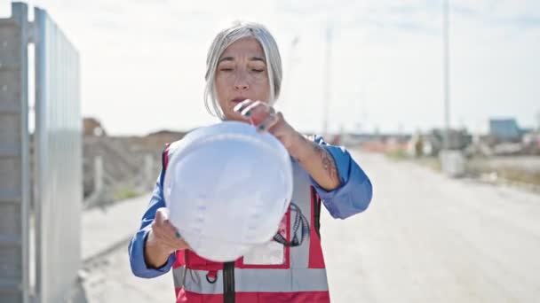 中年灰发女建筑工人带着自信的笑容站在街上 — 图库视频影像
