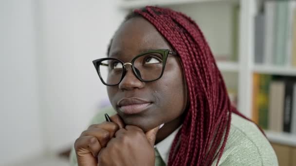 Afrikaanse Vrouw Met Gevlochten Haar Denken Universiteit Bibliotheek — Stockvideo