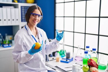 Limon ve hapları laboratuvarda tutan genç ve güzel İspanyol bilim kadını.