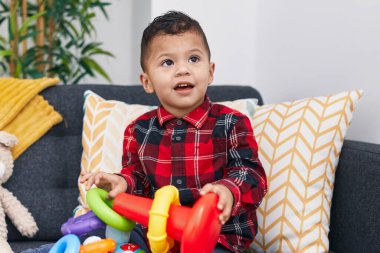 Evdeki kanepede oturan sevimli İspanyol çocuk basketbol oynuyor.