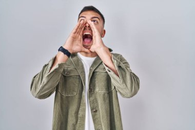 Tecrit edilmiş arka planda duran genç İspanyol adam elleri ağızda bağırarak bağırıyor. 