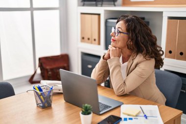 Middle age hispanic woman working with laptop at the office