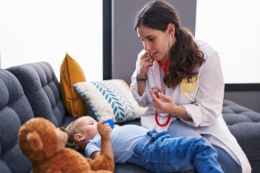 Anne ve oğul doktor evdeki çocuğu muayene ediyor.
