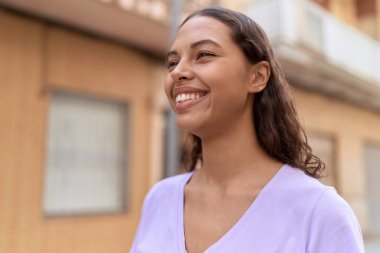 Young african american woman smiling confident looking to the side at street
