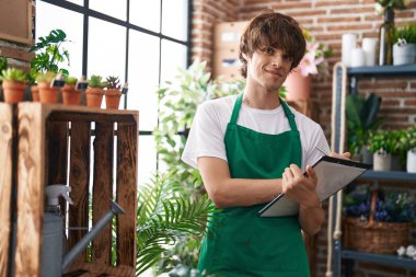 Çiçekçide kendine güvenen genç sarışın bir çiçekçi.