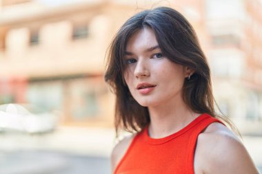 Young caucasian woman standing with serious expression at street