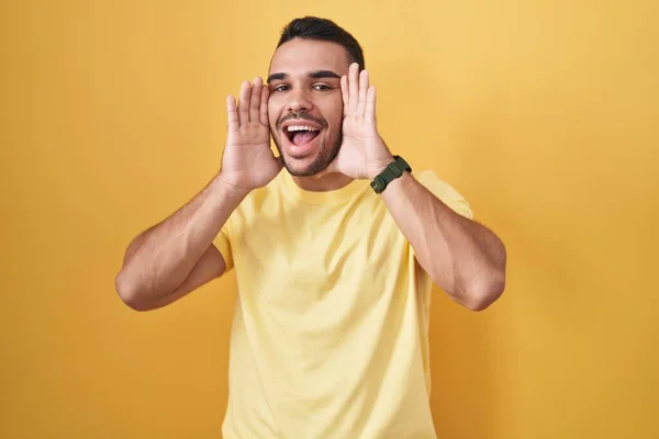Young Hispanic Man Standing Yellow Background Smiling Cheerful Playing Peek — 스톡 사진