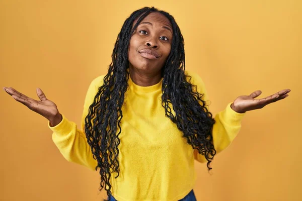 African Woman Standing Yellow Background Clueless Confused Expression Arms Hands — Stock Photo, Image