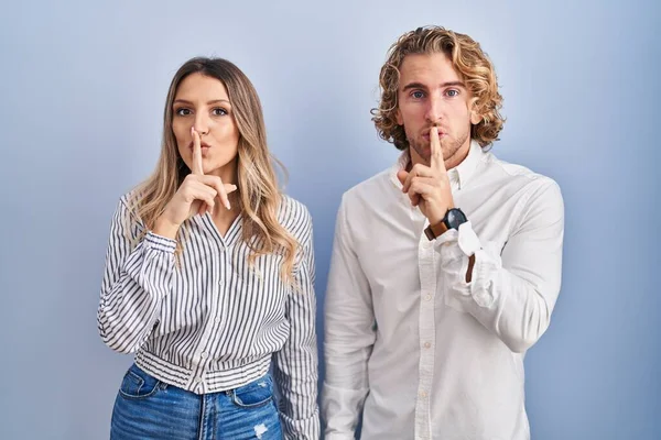 Young Couple Standing Blue Background Asking Quiet Finger Lips Silence — Stock Photo, Image