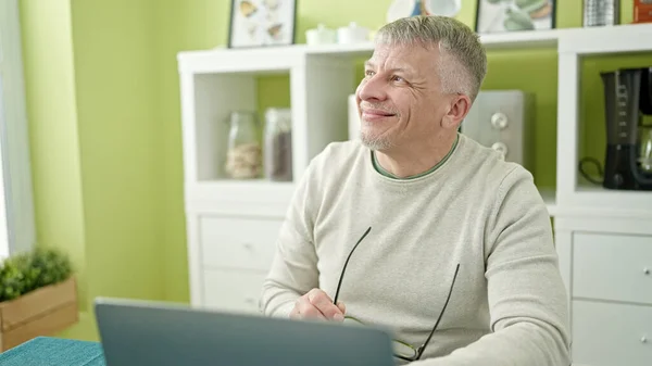 Evdeki Masada Oturan Orta Yaşlı Kır Saçlı Dizüstü Bilgisayar Kullanan — Stok fotoğraf