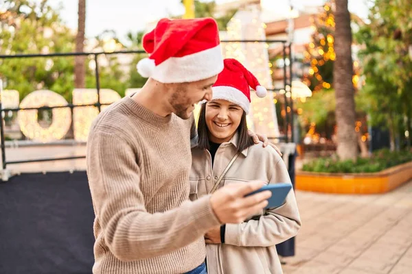 Мужчина Женщина Носят Рождественскую Шляпу Используя Смартфон Парке — стоковое фото