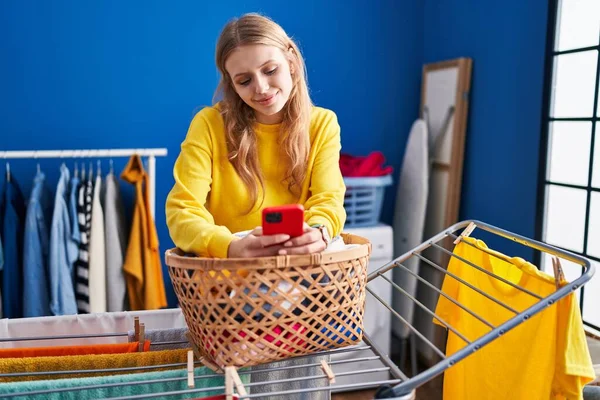 Junge Blonde Frau Hängt Mit Smartphone Kleider Wäscheleine Waschküche — Stockfoto