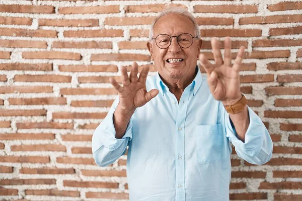 Tuğla Duvarın Üzerinde Duran Yaşlı Adam Dokuz Numaralı Parmaklarını Gösterip — Stok fotoğraf
