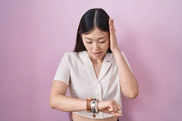 Китайская Молодая Женщина Стоит Розовом Фоне Глядя Часы Время Волновался — стоковое фото