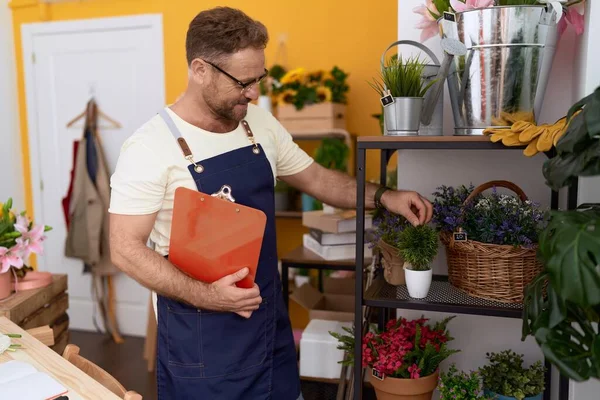 Middle Age Man Florist Touching Plant Holding Clipboard Flower Shop — Stock Photo, Image