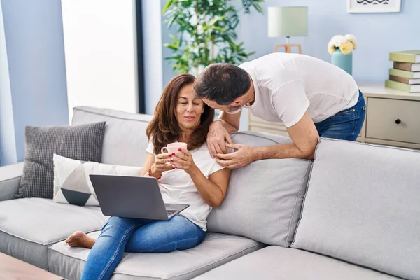 中年男人和女人在家里用笔记本电脑喝咖啡 — 图库照片