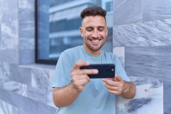 Genç Spanyol Adam Gülümsüyor Sokakta Akıllı Telefondan Videolar Izliyor — Stok fotoğraf