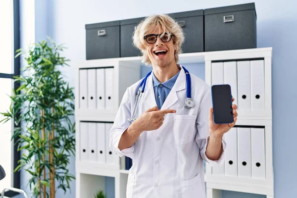 Jovem Médico Homem Mostrando Tela Smartphone Sorrindo Feliz Apontando Com — Fotografia de Stock