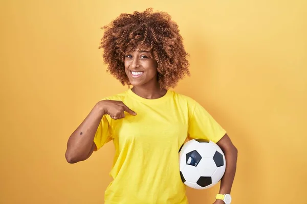 年轻的惊慌失措的女人 卷曲的头发 拿着足球 手指对着一个微笑的人 快乐而自豪 — 图库照片