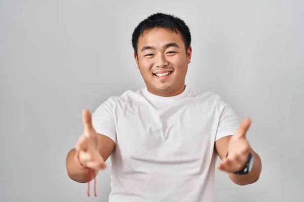 Młody Chińczyk Stojący Nad Białym Tłem Uśmiechnięty Radosne Ręce Oferujące — Zdjęcie stockowe