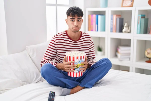 Ung Latinamerikan Äter Popcorn Sittandes Sängen Och Ser Film Deprimerad — Stockfoto