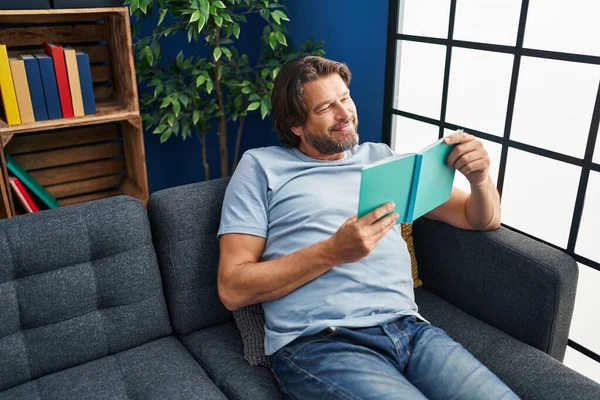 Hombre Mediana Edad Leyendo Libro Sentado Sofá Casa —  Fotos de Stock