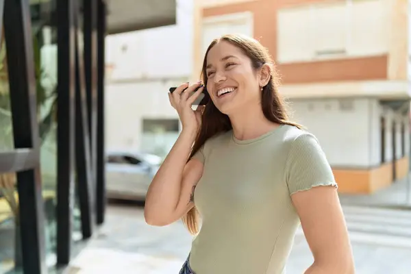 若い美しい女性の笑顔自信を持ってリスニング音声メッセージによるスマートフォンでストリート — ストック写真