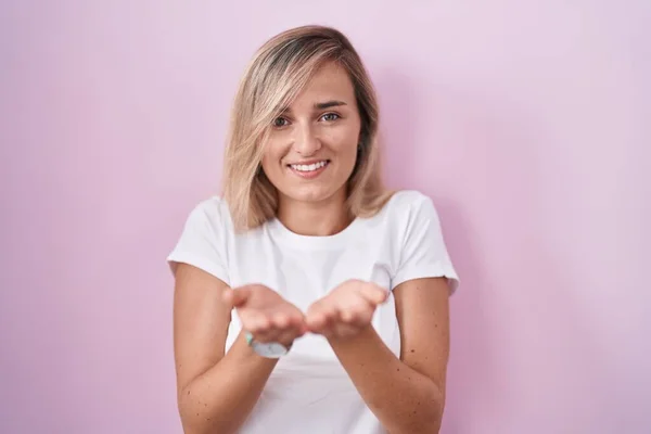 Mulher Loira Jovem Sobre Fundo Rosa Sorrindo Com Mãos Palmas — Fotografia de Stock