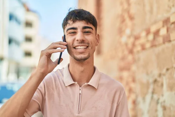 Joven Hombre Hispano Sonriendo Confiado Hablando Teléfono Inteligente Calle —  Fotos de Stock
