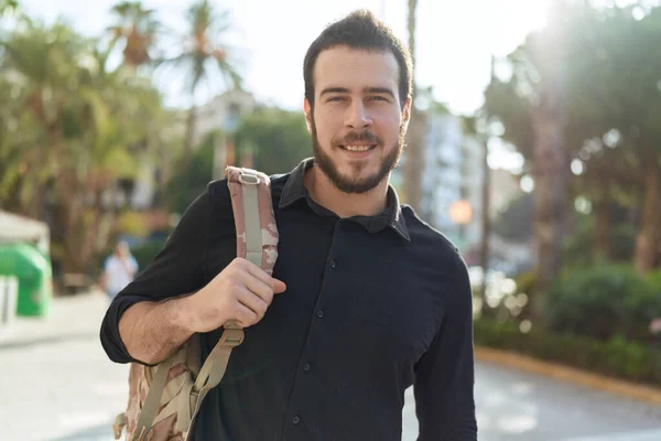 年轻的惊慌失措的男人带着背包在街上笑得很自信 — 图库照片