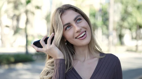 Молодая Блондинка Улыбается Уверенно Слушая Аудиосообщение Смартфона Парке — стоковое фото