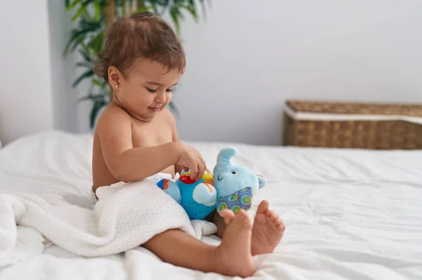 可爱的惊慌失措的宝宝躺在床上 在卧室里玩大象娃娃 — 图库照片