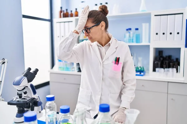 Mujer Joven Que Trabaja Laboratorio Científico Sorprendido Con Mano Cabeza — Foto de Stock