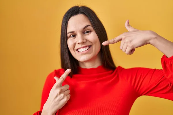 Young Hispanic Woman Standing Yellow Background Smiling Cheerful Showing Pointing — ストック写真