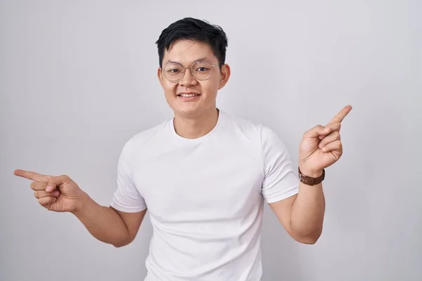 Joven Hombre Asiático Pie Sobre Fondo Blanco Sonriendo Confiado Señalando — Foto de Stock