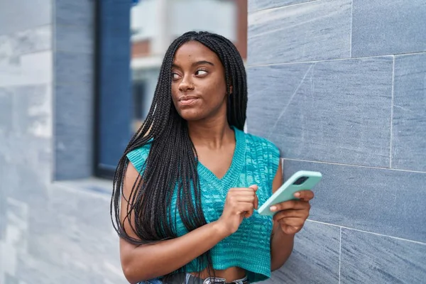 アフリカ系アメリカ人女性が路上でスマートフォンを使う — ストック写真
