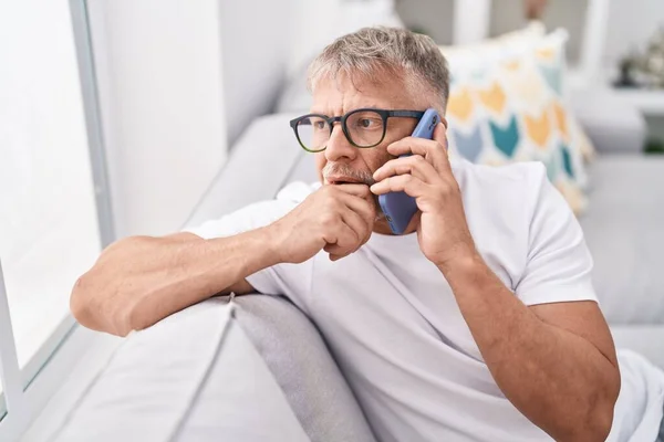 Orta Yaşlı Kır Saçlı Akıllı Telefondan Endişelenen Adam Evdeki Kanepede — Stok fotoğraf