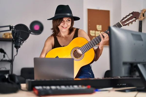 在音乐工作室举行网上古典吉他手音乐会的中年女音乐家 — 图库照片