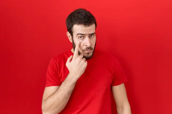 Young Hispanic Man Wearing Casual Red Shirt Pointing Eye Watching — Stock Photo, Image