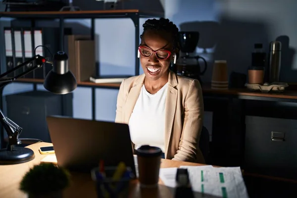 美人黒人女性がオフィスで働く夜のウインクでカメラを見ながらセクシー表情 陽気で幸せな顔 — ストック写真