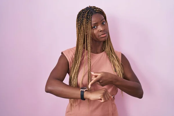 Африканская Американка Плетеными Волосами Стоящая Розовом Фоне Спешке Указывая Время — стоковое фото