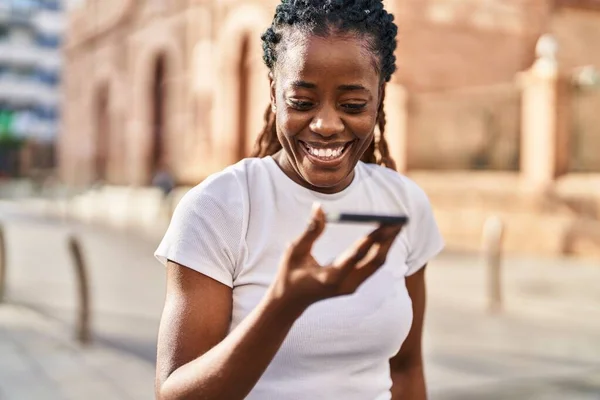 アフリカ系アメリカ人の女性が路上でスマートフォンで自信を持って話しています — ストック写真
