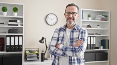 Middle age man business worker smiling confident standing with arms crossed gesture at office